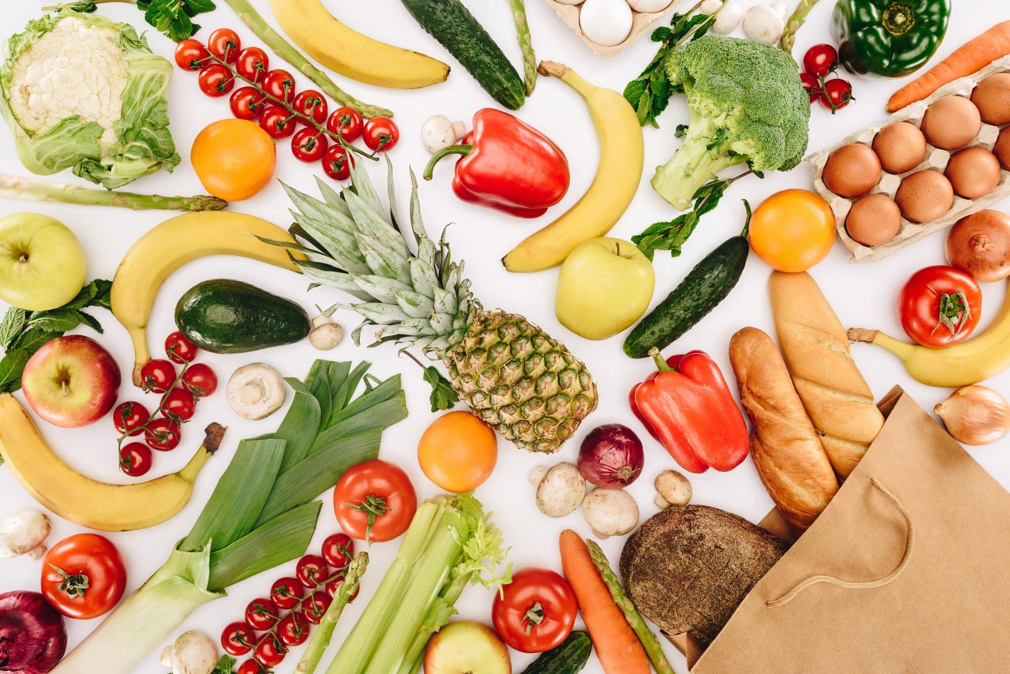 Fruits and vegetables laying on a white table