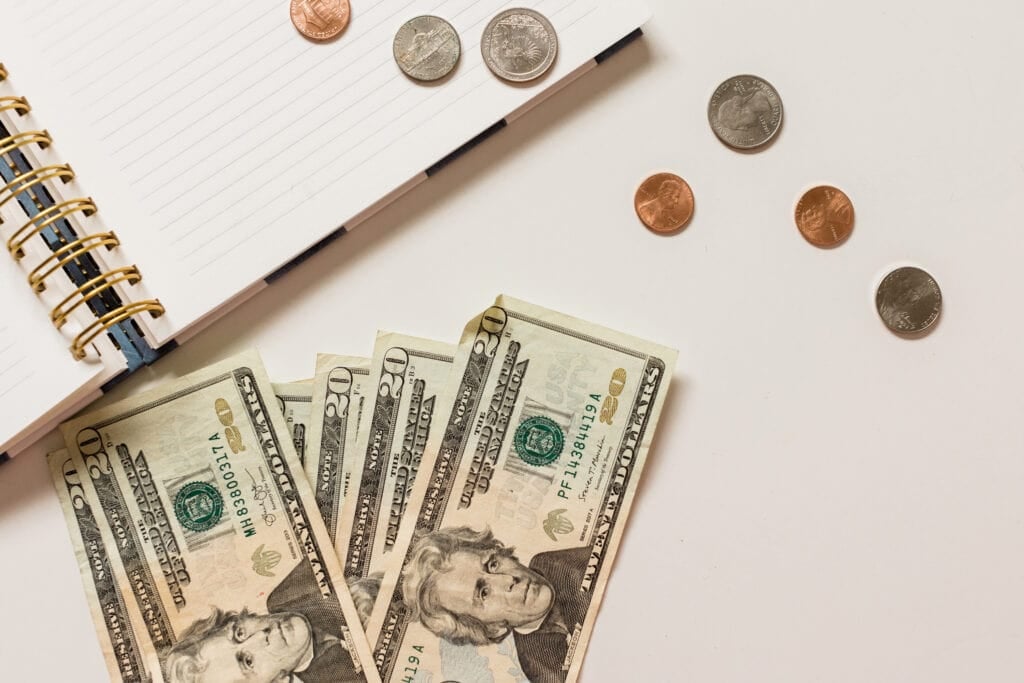 picture of money and journal on table for article how to decide what business to start