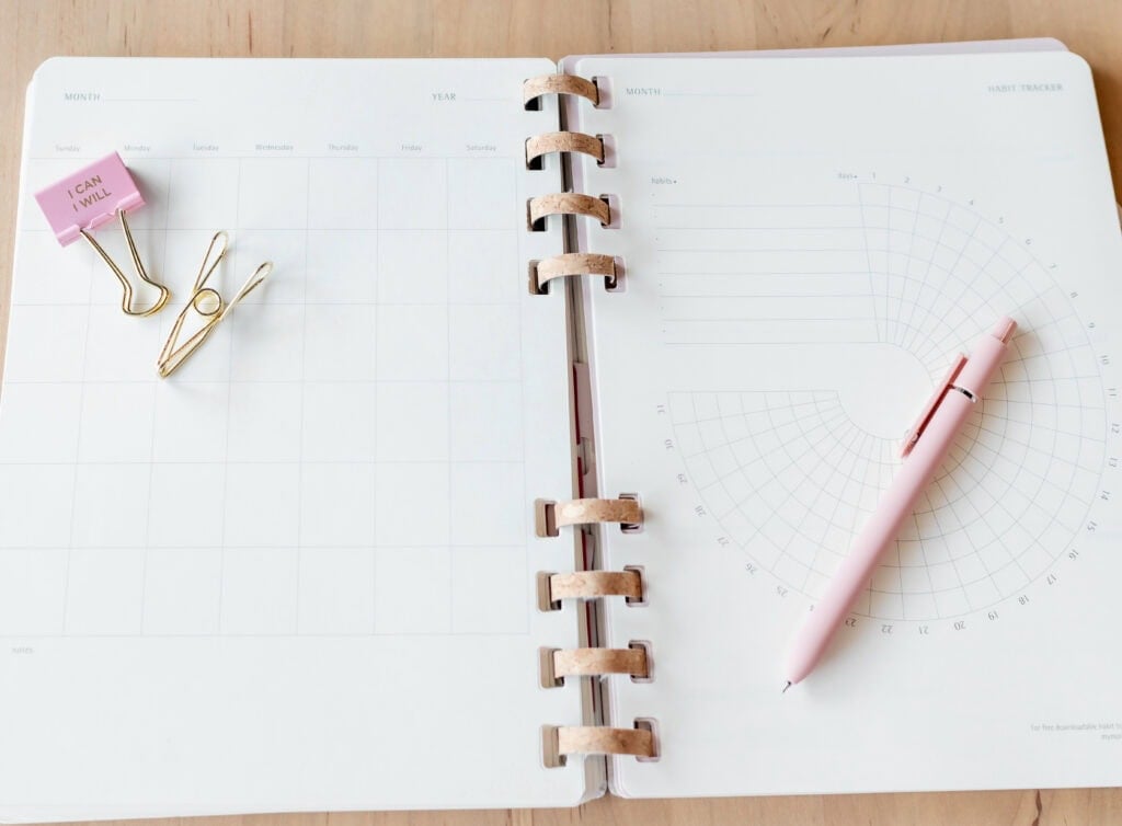 Journal on a desk with a clip that says "I CAN I WILL" for article how to get your life together checklist